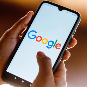 Person holding a smartphone displaying a web design by JABstract, an expert in website development and SEO services.