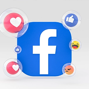 Blue Facebook icon with floating like, love, laugh, angry, and thumbs up reactions on light background for social media integration.
